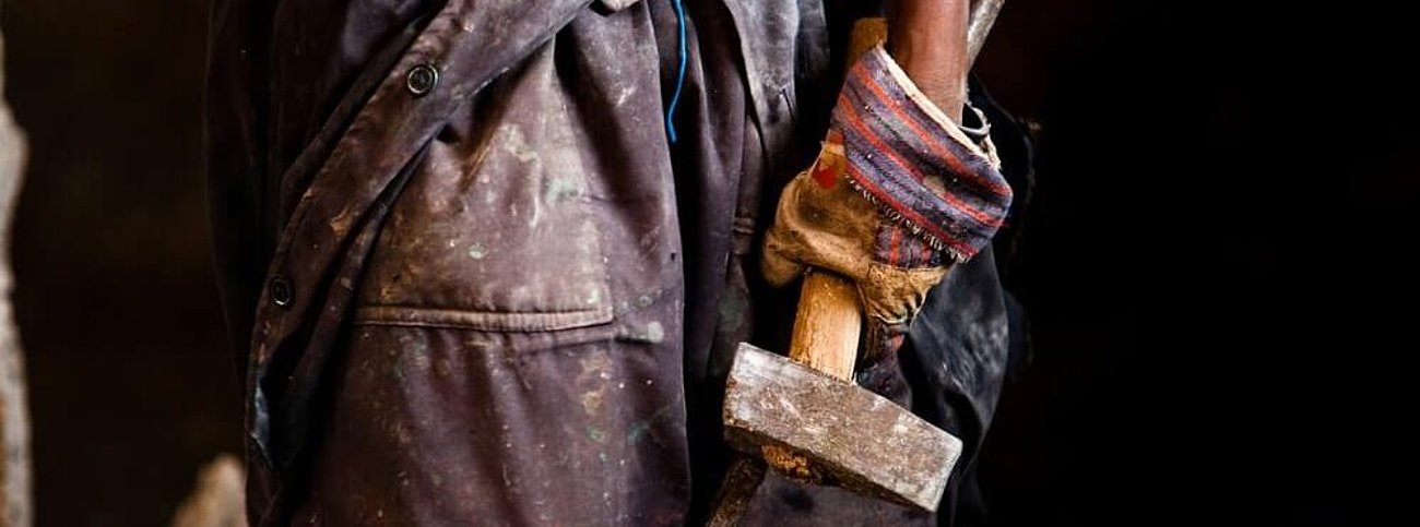 Person in einer Arbeitssituation als Symbol für Zwangsarbeit und die EU-Zwangsarbeitsverordnung zum Schutz von Menschenrechten in Lieferketten.