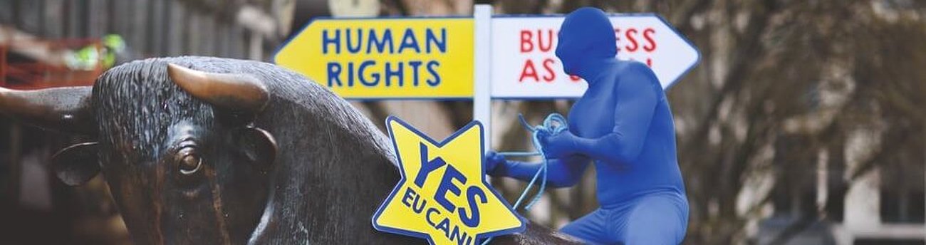 Die Lieferkettengesetze in Deutschland und der EU: Zwischen Regulierung und politischem Druck Statue eines Stiers mit einer Person in blauem Ganzkörperanzug auf dem Rücken.